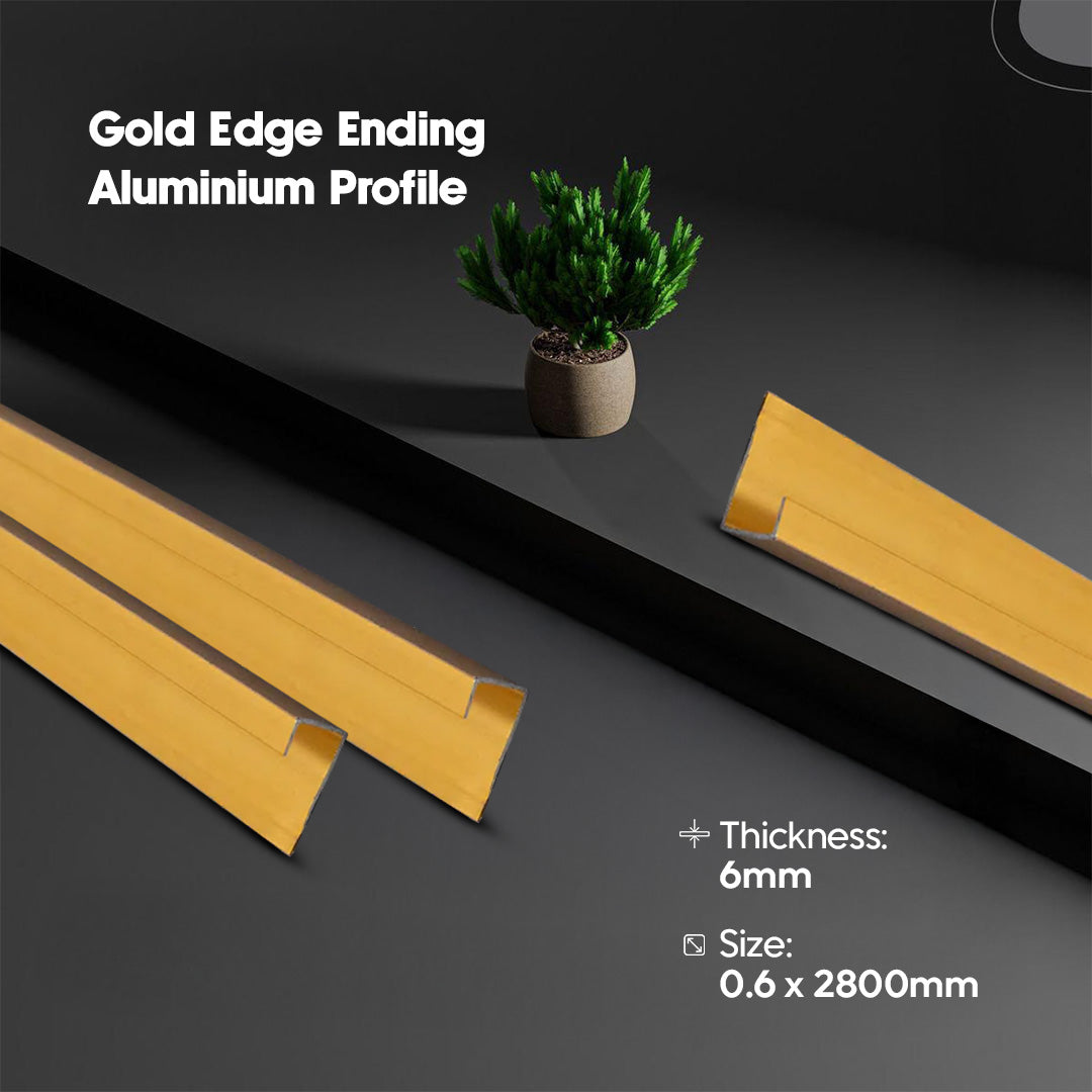 Gold edge ending aluminium profile on a dark surface with a plant for scale.